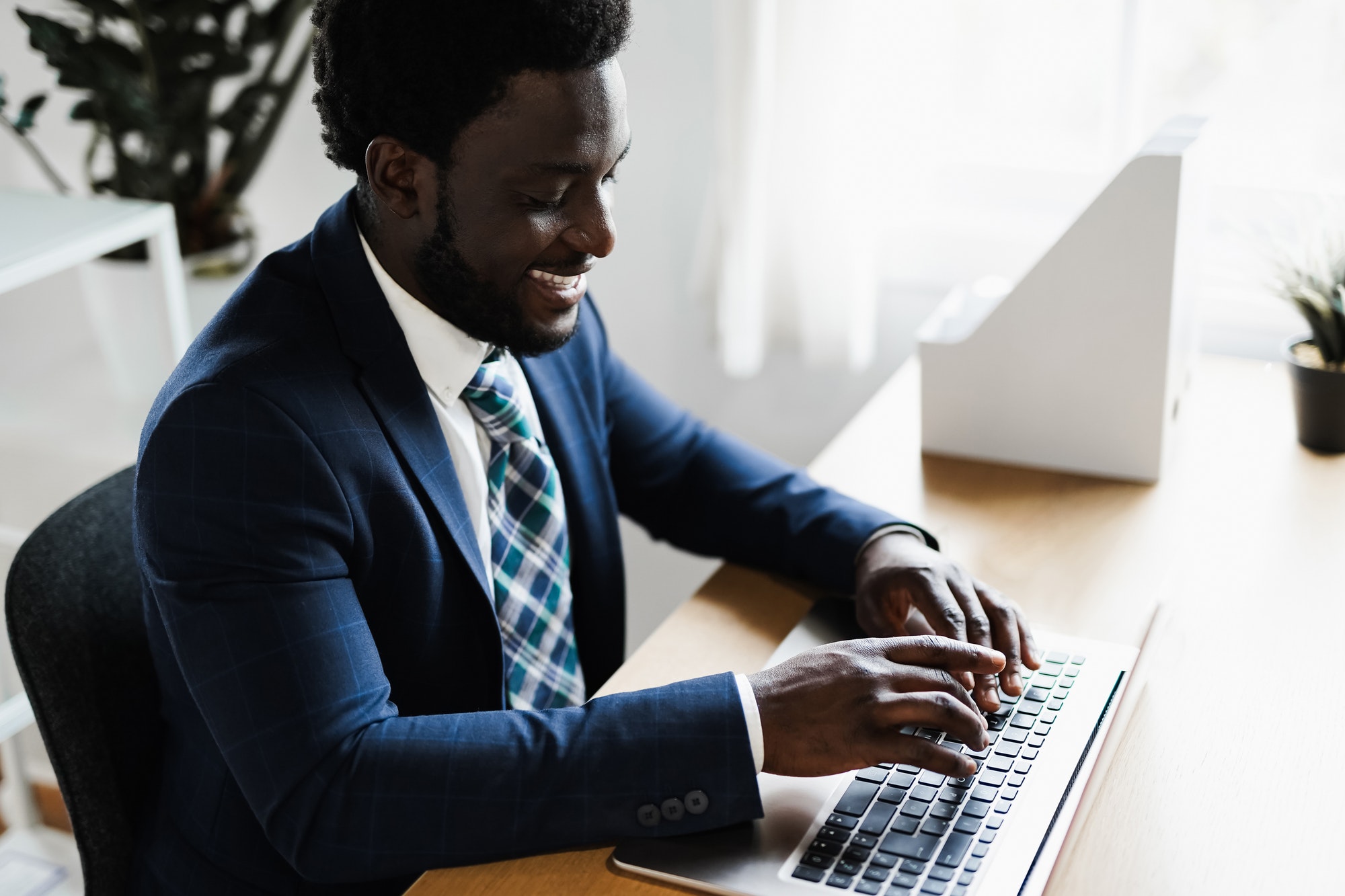 Business african man working inside modern office using computer laptop - Focus on face
